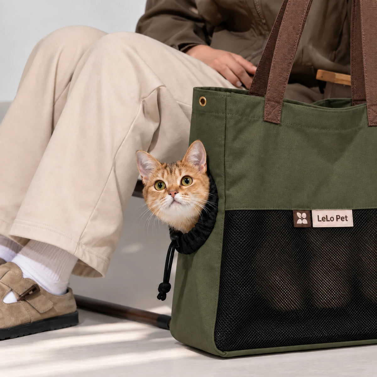 LeLo Pet UrbanTote λαδί τσάντα μεταφοράς γάτας με μεγάλο μαύρο mesh αερισμού και γάτα να κοιτάζει από το ρυθμιζόμενο πλευρικό άνοιγμα κατά τη μετακίνηση