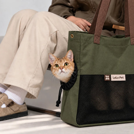 LeLo Pet UrbanTote λαδί τσάντα μεταφοράς γάτας με μεγάλο μαύρο mesh αερισμού και γάτα να κοιτάζει από το ρυθμιζόμενο πλευρικό άνοιγμα κατά τη μετακίνηση